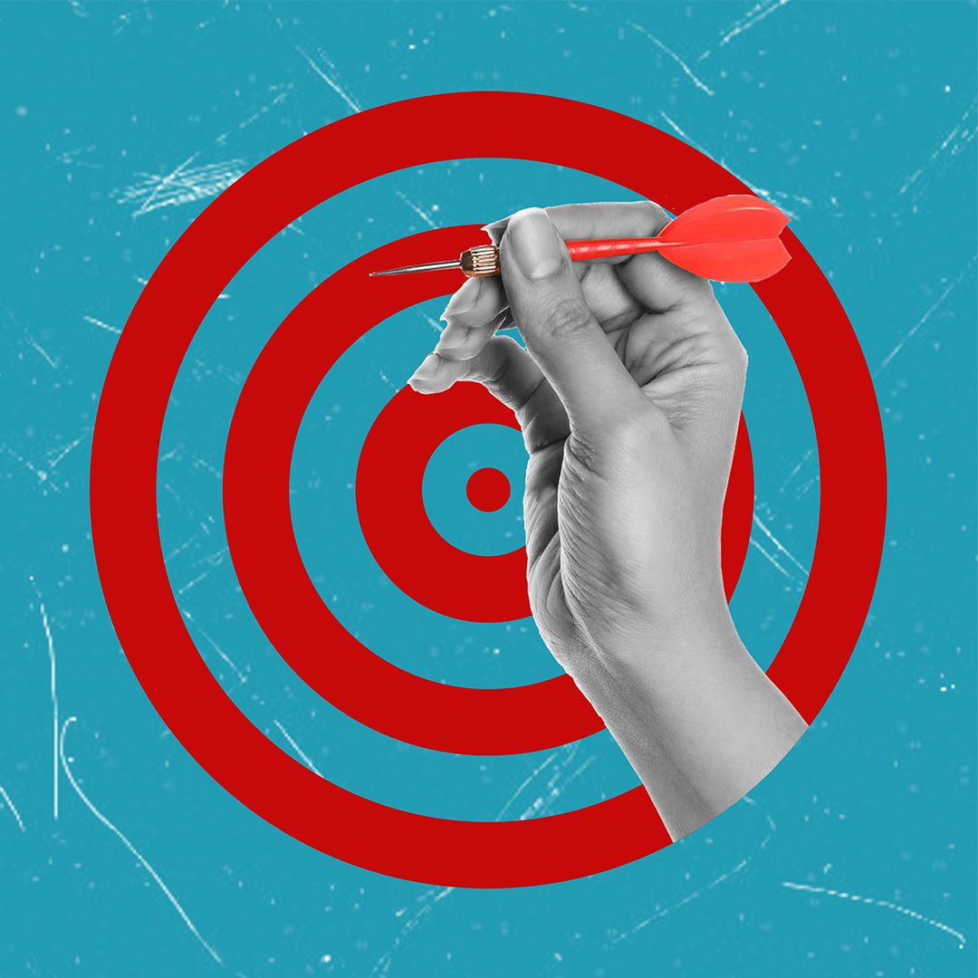 Hand holding a red dart aimed at the bullseye of a red target on a textured blue background, symbolizing precision and targeted performance.