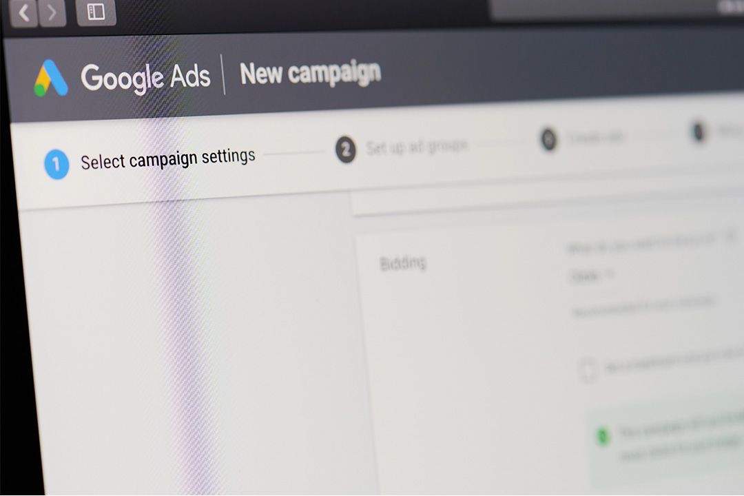 Close-up of a computer screen displaying the Google Ads campaign setup interface, highlighting the step to select campaign settings.