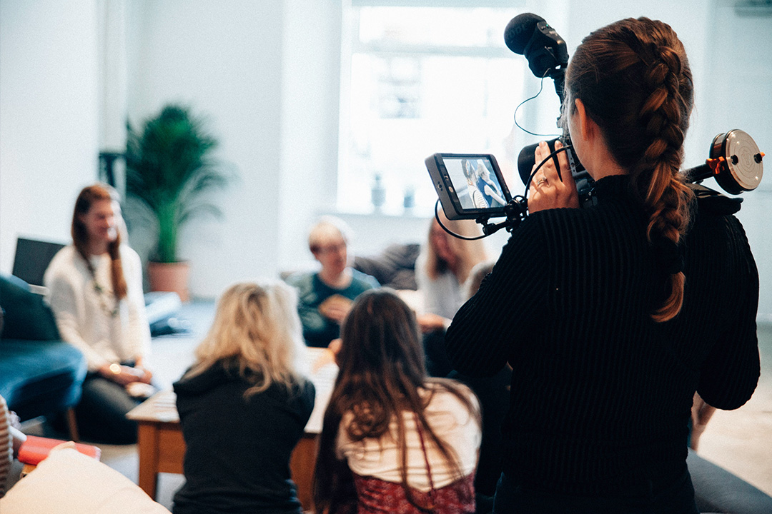 Camerawoman filming on set, capturing authentic behind-the-scenes storytelling.