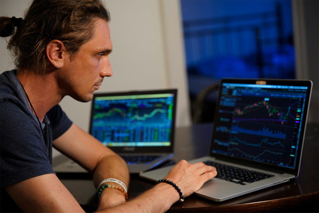 Marketer reviewing graphs across two laptop dashboards, illustrating analysis and oversight in Google Ads campaigns.