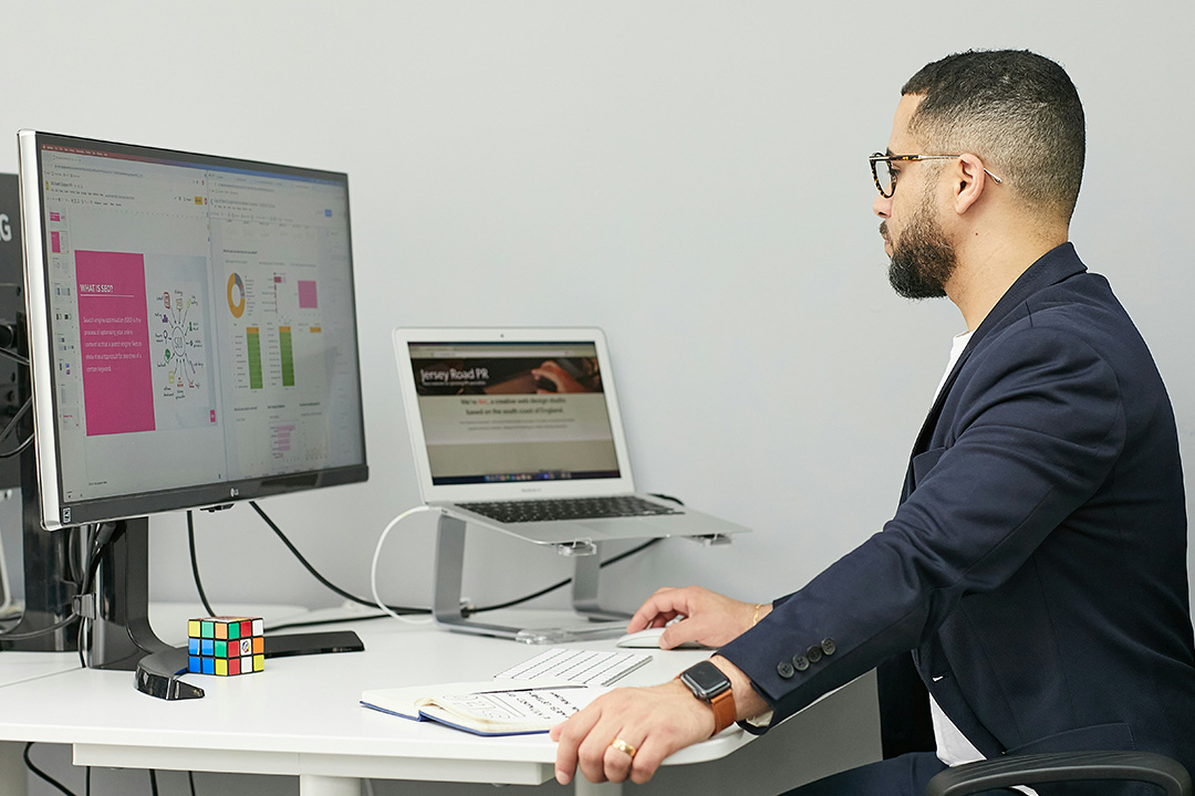 Marketing professional working on a laptop in a collaborative environment, illustrating the importance of continuous AdTech training and team development.