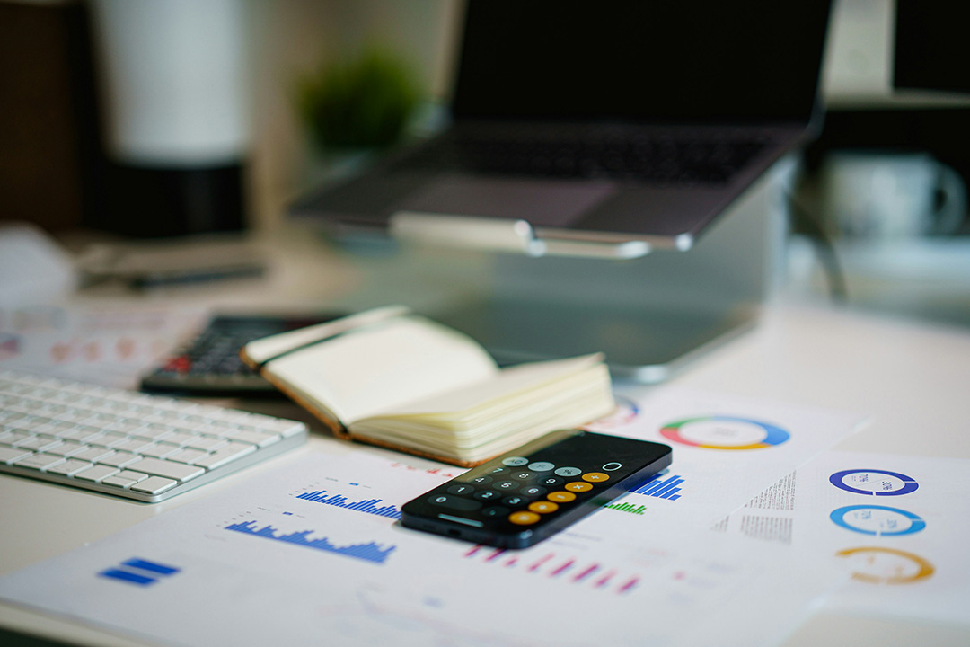 A table top with a calculator and spreadsheets, documenting data and analytics for. budgeting.